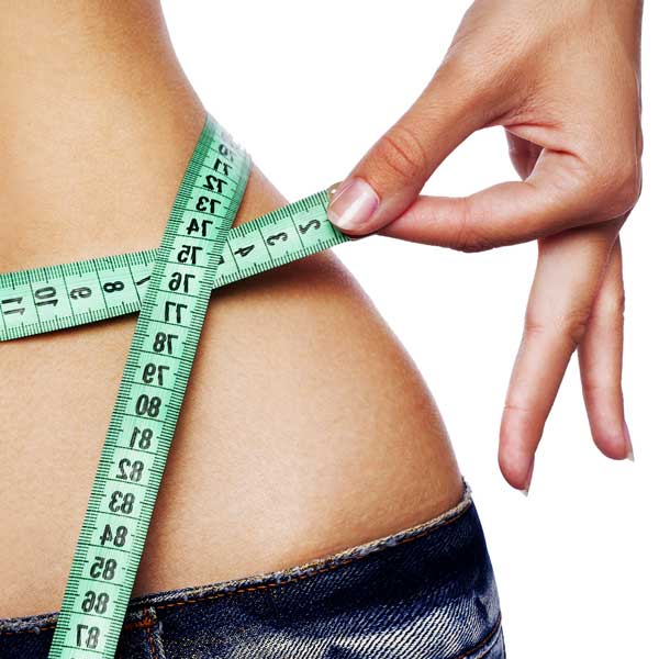 Measuring waist with a green tape measure.